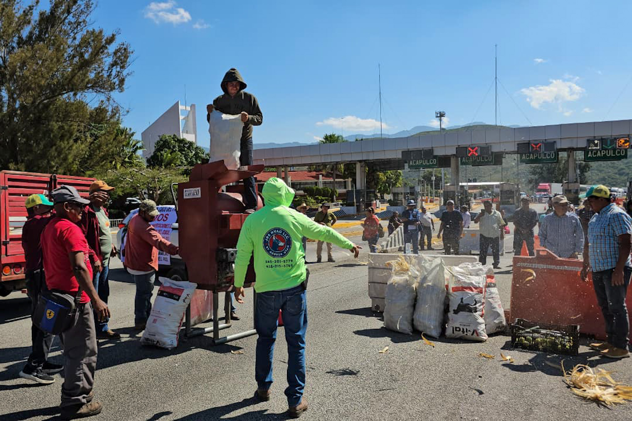 Campesinos desgranan mazorcas en la caseta de cobro de Palo Blanco, en Guerrero