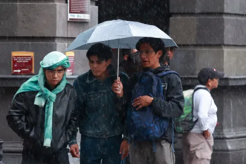 Poblanos se tuvieron que proteger y correr por la lluvia de este viernes.
