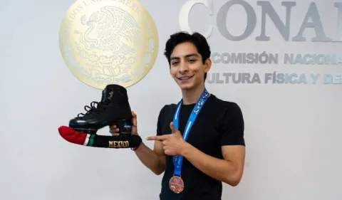 Donovan Carrillo, seleccionado mexicano de patinaje artístico sobre hielo, luce su medalla de bronce y los patines con los que ganó su pase olímpico.
