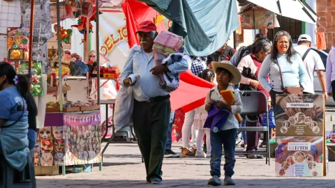 Bajo los rayos del sol y con paso lento, un abuelo y su nieto recorren las calles en la ciudad de Tlaxcala ofreciendo varios productos.