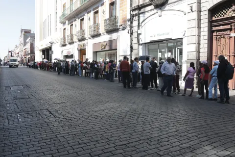 Largas filas para el Banco del Bienestar en avenida Reforma en el Centro Histórico de la ciudad de Puebla.