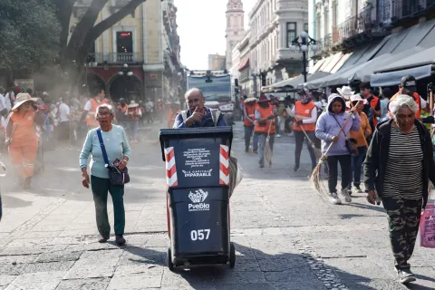 Naranjitas mantienen limpias las calles de Puebla después de Procesión.