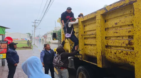Rescatan a estudiantes de Coronango con camiones de volteo tras fuertes lluvias.